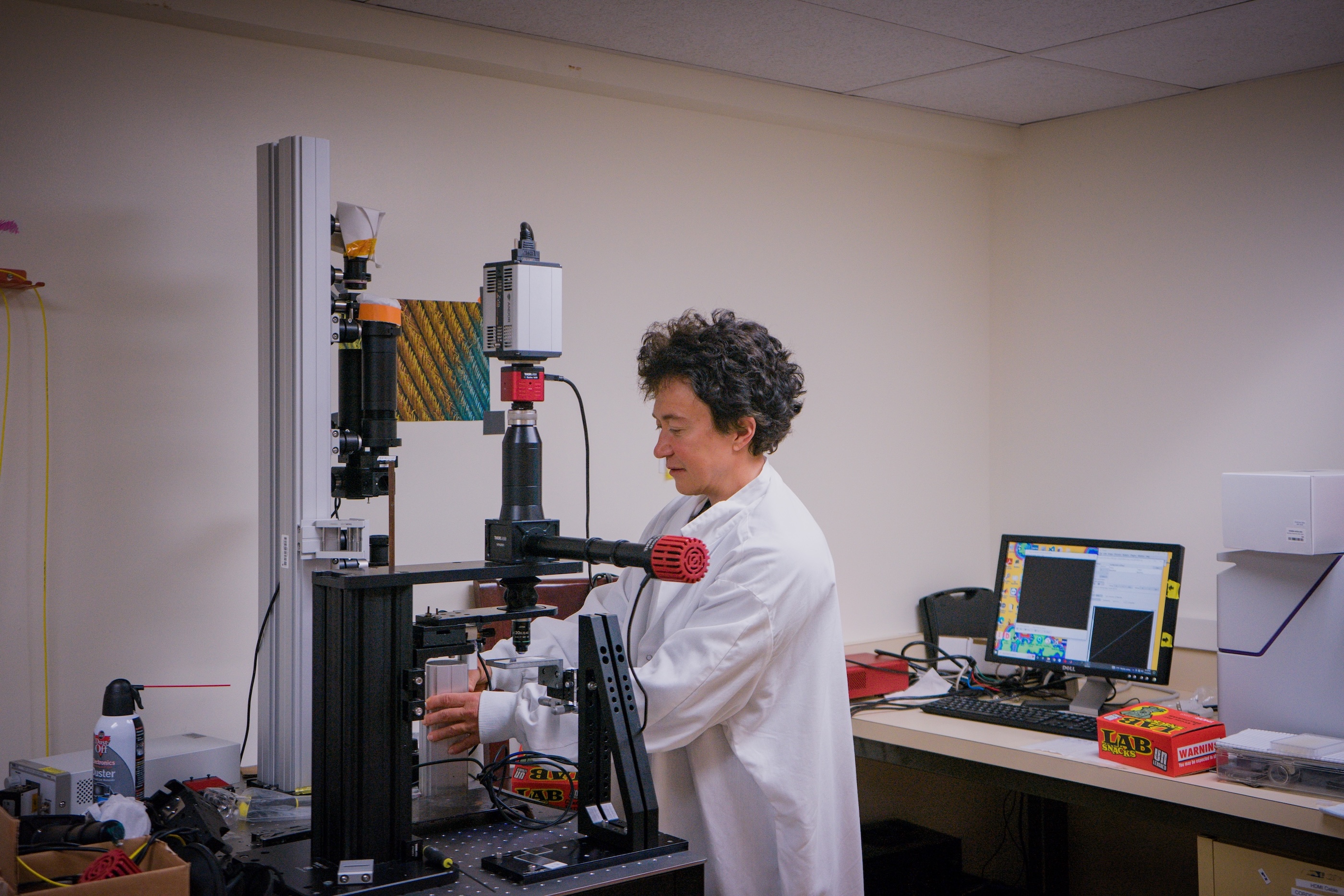 Professor in research lab with large microscope